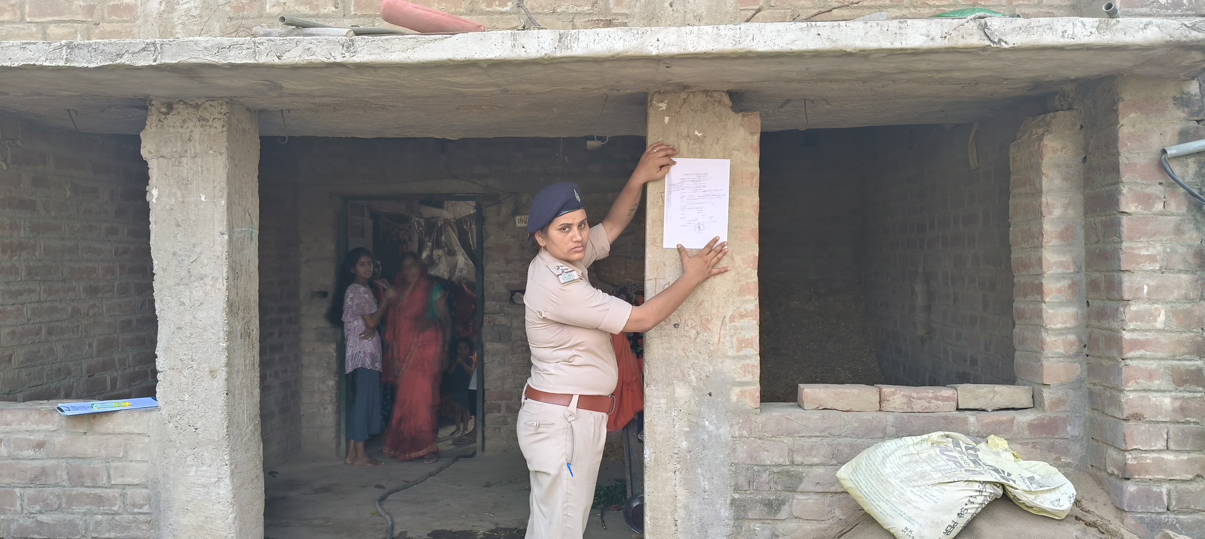 कोईलवर हत्याकांड मे फरार आरोपित के घर पुलिस ने इश्तेहार चिपकाया।